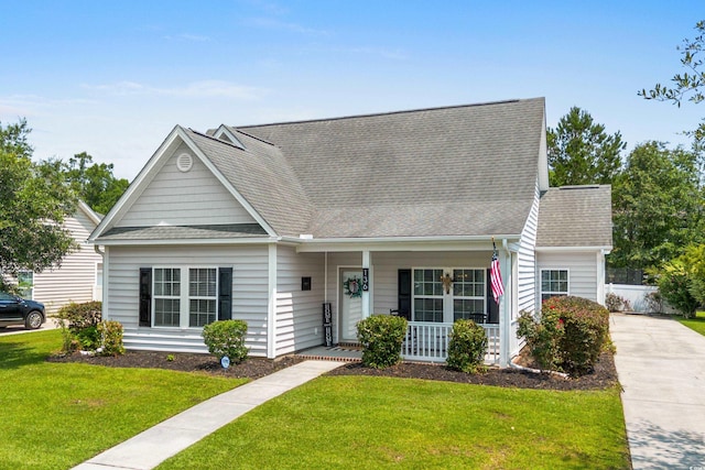 136 Southbury Dr, Myrtle Beach, SC 29588 - view of front of house with covered porch, a front lawn, a shingled roof, and concrete driveway