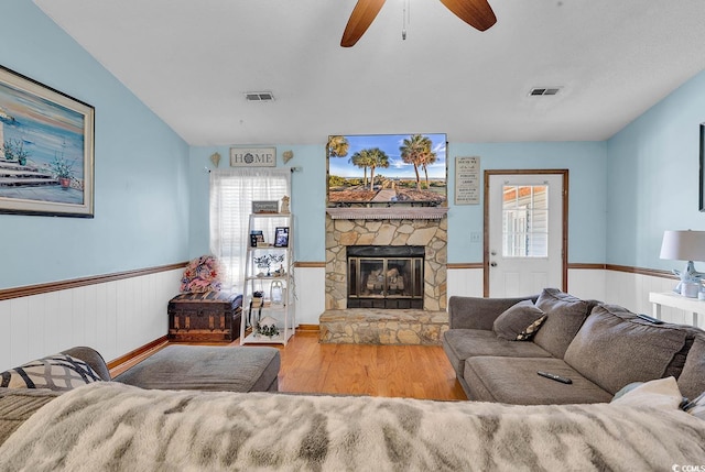 405 Flagstone Dr, Myrtle Beach, SC 29588 - living room featuring a wainscoted wall, wood finished floors, a stone fireplace, and ceiling fan