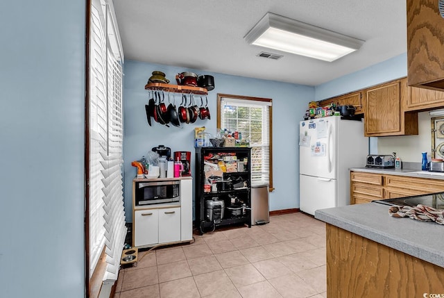 405 Flagstone Dr, Myrtle Beach, SC 29588 - kitchen with stainless steel microwave, freestanding refrigerator, light countertops, light tile patterned floors, and baseboards