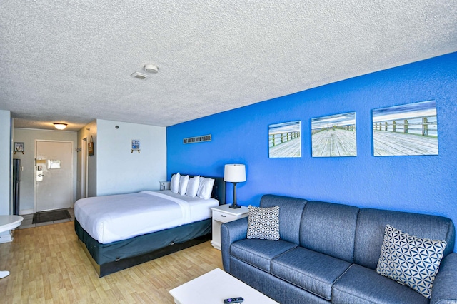 1207 S Ocean Blvd Unit 51012, Myrtle Beach, SC 29577 - bedroom with a textured ceiling, a textured wall, and light wood-style flooring