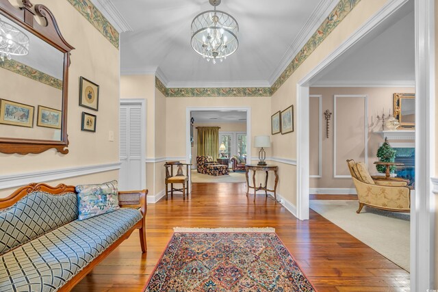 1259 Oatland Lake Rd, Pawleys Island, SC 29585 - entrance foyer featuring a chandelier, hardwood / wood-style floors, and ornamental molding