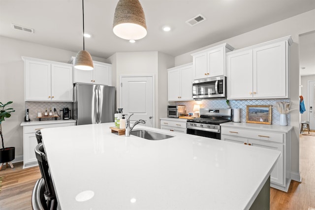 1523 Wood Stork Dr, Conway, SC 29526 - kitchen featuring appliances with stainless steel finishes, a sink, backsplash, a kitchen island with sink, and light countertops