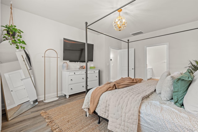 1523 Wood Stork Dr, Conway, SC 29526 - bedroom featuring light wood-type flooring, baseboards, a chandelier, and connected bathroom