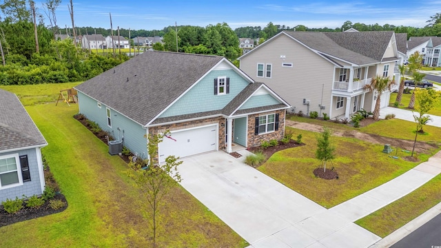 1523 Wood Stork Dr, Conway, SC 29526 - view of front of property with concrete driveway, stone siding, central AC unit, a residential view, and a front lawn