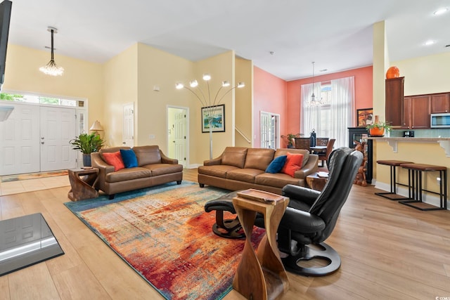 106 Cypress Creek Dr, Murrells Inlet, SC 29576 - living room with a chandelier, light wood-type flooring, and a towering ceiling