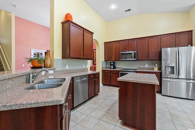 106 Cypress Creek Dr, Murrells Inlet, SC 29576 - kitchen featuring stainless steel appliances, a sink, light tile patterned floors, decorative backsplash, and lofted ceiling