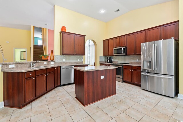 106 Cypress Creek Dr, Murrells Inlet, SC 29576 - kitchen featuring appliances with stainless steel finishes, arched walkways, a peninsula, light tile patterned floors, and tasteful backsplash