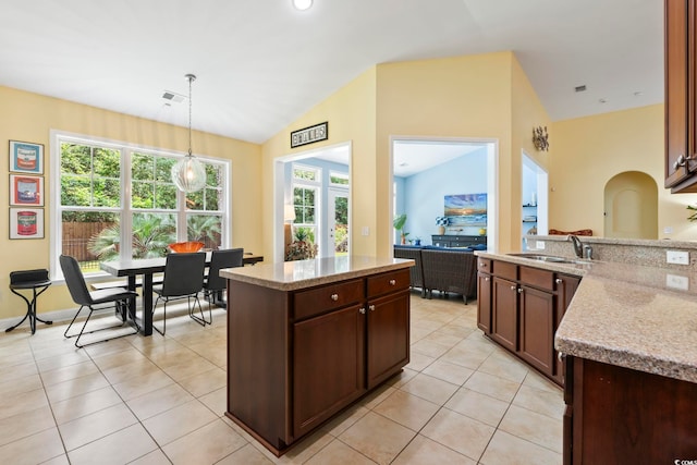 106 Cypress Creek Dr, Murrells Inlet, SC 29576 - kitchen featuring a sink, light tile patterned floors, hanging light fixtures, vaulted ceiling, and light stone countertops