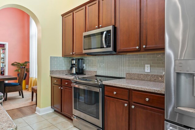 106 Cypress Creek Dr, Murrells Inlet, SC 29576 - kitchen with appliances with stainless steel finishes, arched walkways, decorative backsplash, and baseboards