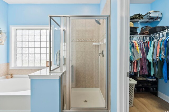 106 Cypress Creek Dr, Murrells Inlet, SC 29576 - bathroom featuring a bath, a walk in closet, a shower stall, and wood finished floors