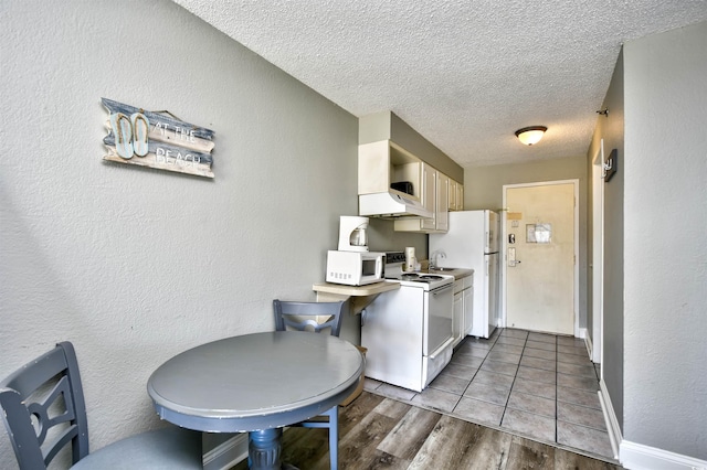 1207 S Ocean Blvd Unit 50809, Myrtle Beach, SC 29577 - kitchen featuring white appliances, wood finished floors, a textured ceiling, custom range hood, and a textured wall