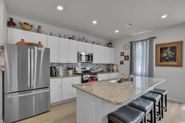 79 S Reindeer Rd, Surfside Beach, SC 29575 - kitchen with stainless steel appliances, a sink, light wood-type flooring, white cabinets, and recessed lighting