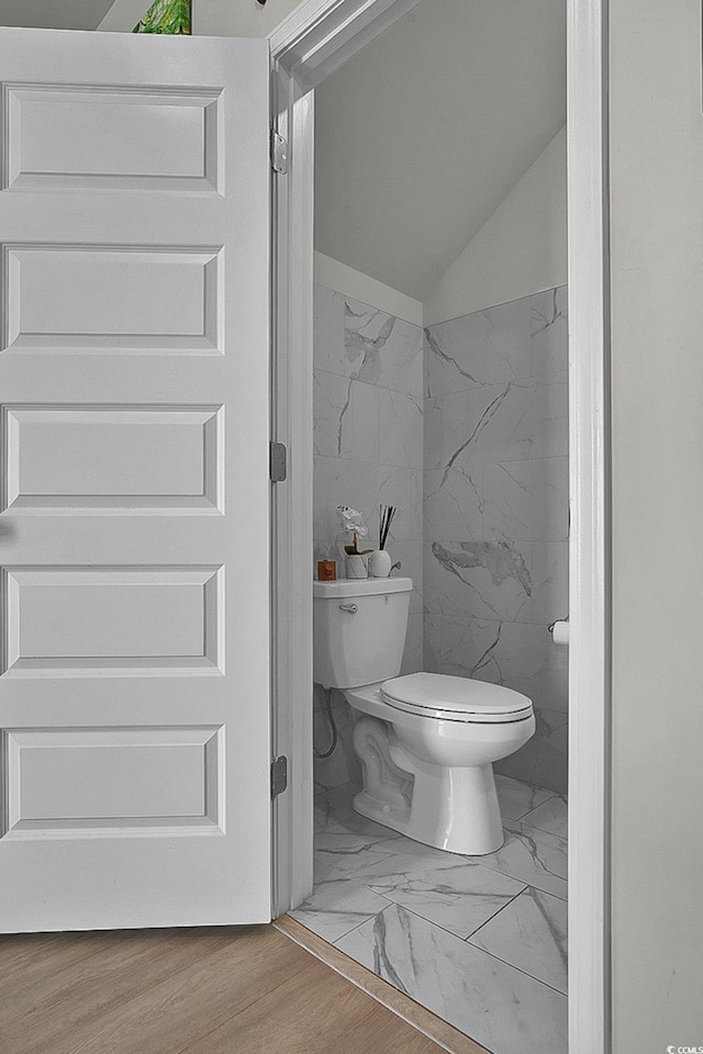 79 S Reindeer Rd, Surfside Beach, SC 29575 - bathroom featuring toilet, marble look tiles, and vaulted ceiling