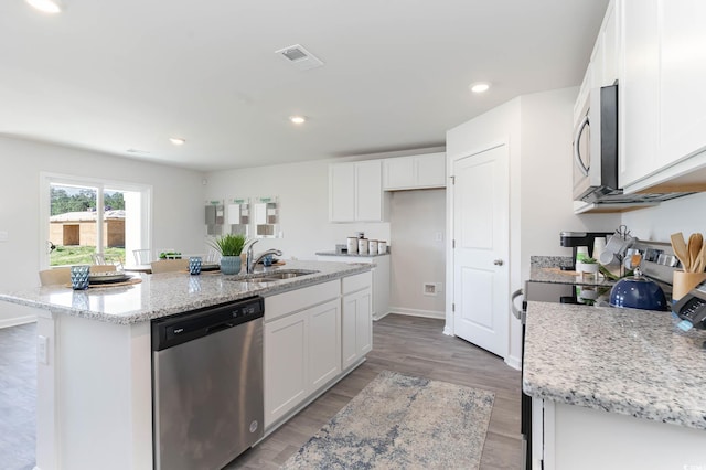 169 Dagger Ct, Myrtle Beach, SC 29588 - kitchen featuring appliances with stainless steel finishes, a sink, white cabinetry, a kitchen island with sink, and light stone counters
