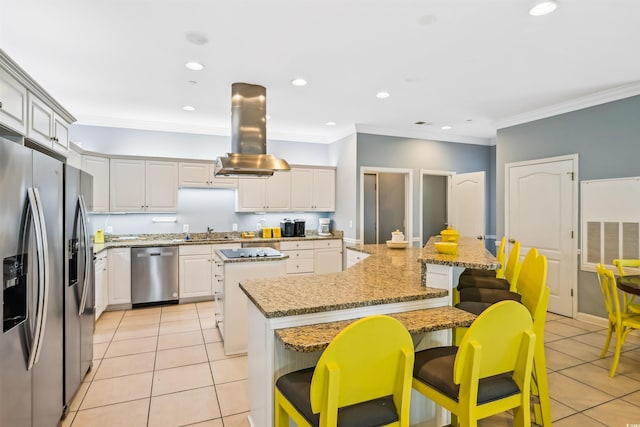 931 S Ocean Blvd, North Myrtle Beach, SC 29582 - kitchen with appliances with stainless steel finishes, island range hood, a large island, light tile patterned floors, and a breakfast bar area