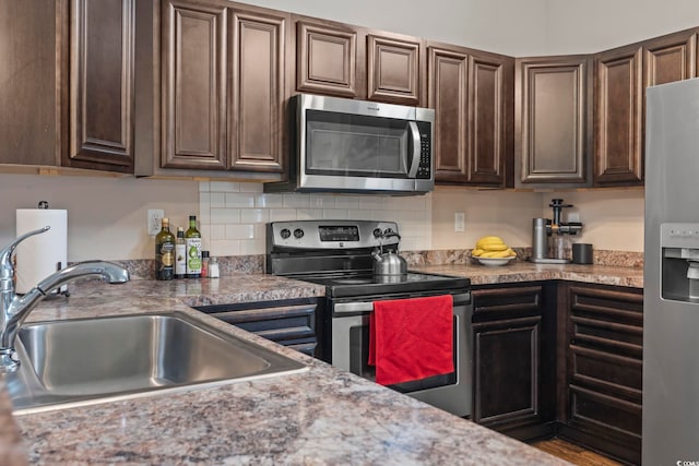 282 Foxpath Loop, Myrtle Beach, SC 29588 - kitchen featuring stainless steel appliances, a sink, dark brown cabinetry, tasteful backsplash, and light countertops