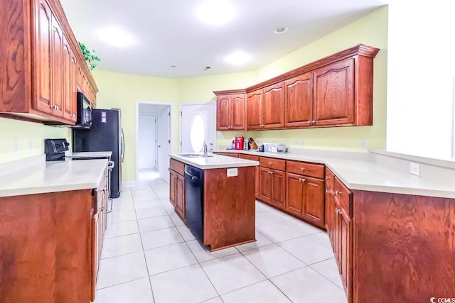 2499 Burning Tree Ln, Little River, SC 29566 - kitchen with a sink, black appliances, an island with sink, light countertops, and light tile patterned floors