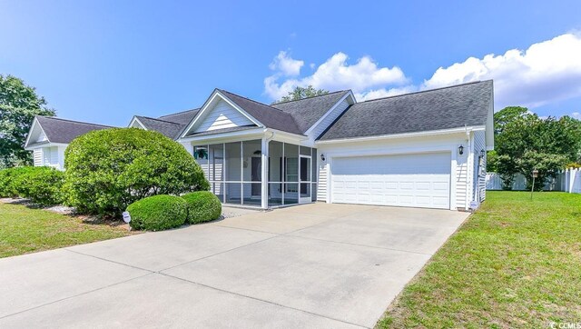 2499 Burning Tree Ln, Little River, SC 29566 - view of front of home with a sunroom, a garage, a front lawn, concrete driveway, and a shingled roof
