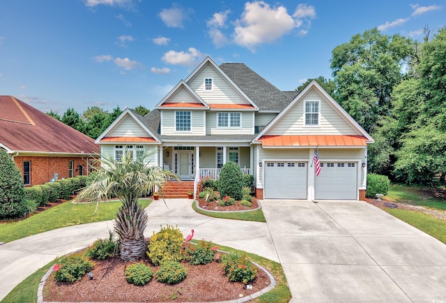 504 Sea Vista Ln, North Myrtle Beach, SC 29582 - view of front facade featuring a standing seam roof, concrete driveway, covered porch, and a shingled roof