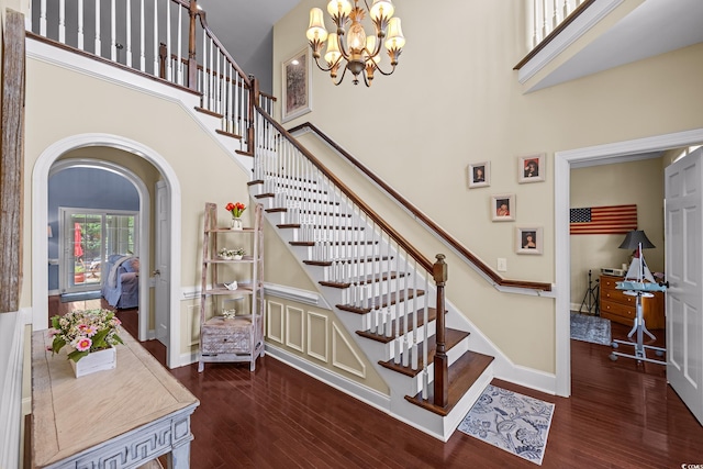504 Sea Vista Ln, North Myrtle Beach, SC 29582 - stairs featuring a high ceiling, arched walkways, wood finished floors, baseboards, and a chandelier