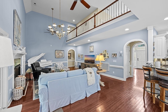 504 Sea Vista Ln, North Myrtle Beach, SC 29582 - living area with arched walkways, a fireplace, a towering ceiling, ceiling fan, and dark wood finished floors