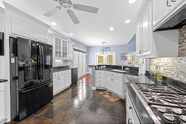 504 Sea Vista Ln, North Myrtle Beach, SC 29582 - kitchen featuring black fridge, range hood, dishwashing machine, dark countertops, and a peninsula