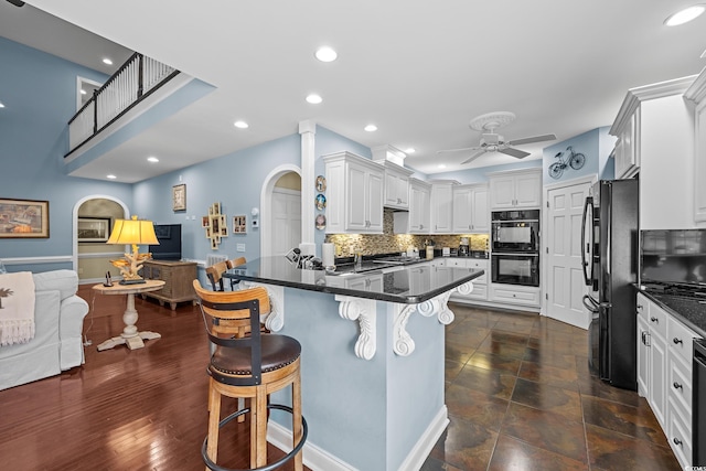 504 Sea Vista Ln, North Myrtle Beach, SC 29582 - kitchen with open floor plan, black appliances, a ceiling fan, dark countertops, and a peninsula
