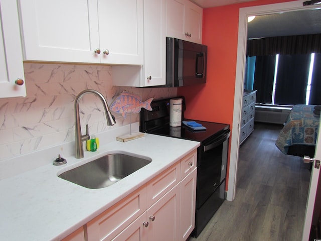 6804 N Ocean Blvd Unit 1023, Myrtle Beach, SC 29572 - kitchen with black appliances, white cabinetry, tasteful backsplash, and wood finished floors