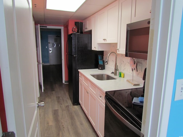 6804 N Ocean Blvd Unit 1023, Myrtle Beach, SC 29572 - kitchen featuring black appliances, light wood-style flooring, backsplash, white cabinets, and light countertops