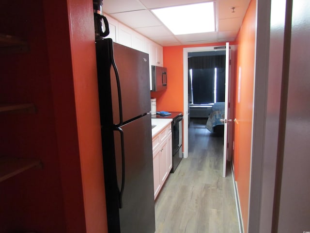 6804 N Ocean Blvd Unit 1023, Myrtle Beach, SC 29572 - kitchen featuring freestanding refrigerator, black range with electric stovetop, white cabinetry, light wood finished floors, and light countertops