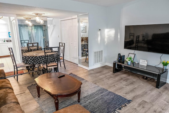 4505 N Kings Hwy # E2, Myrtle Beach, SC 29577 - living room with wood finished floors, a chandelier, and baseboards