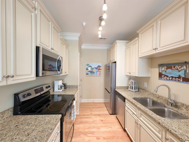 82 Mingo Dr Unit 2D, Pawleys Island, SC 29585 - kitchen featuring appliances with stainless steel finishes, a sink, cream cabinets, light wood-style flooring, and baseboards