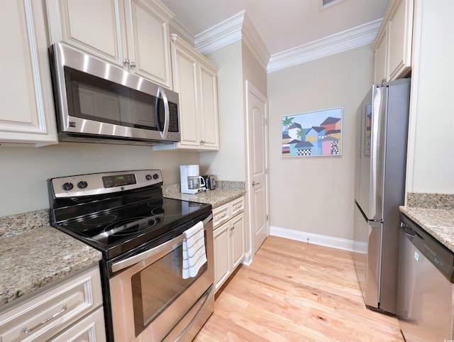 82 Mingo Dr Unit 2D, Pawleys Island, SC 29585 - kitchen with stainless steel appliances, crown molding, light wood-type flooring, baseboards, and light stone countertops