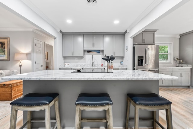 1223 Naylor Ave, Myrtle Beach, SC 29577 - kitchen with stainless steel refrigerator with ice dispenser, gray cabinetry, crown molding, light stone countertops, and a kitchen breakfast bar