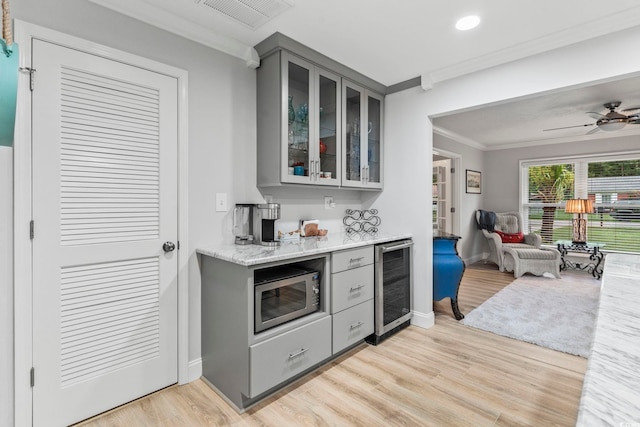 1223 Naylor Ave, Myrtle Beach, SC 29577 - kitchen with gray cabinetry, beverage cooler, stainless steel microwave, ornamental molding, and open floor plan