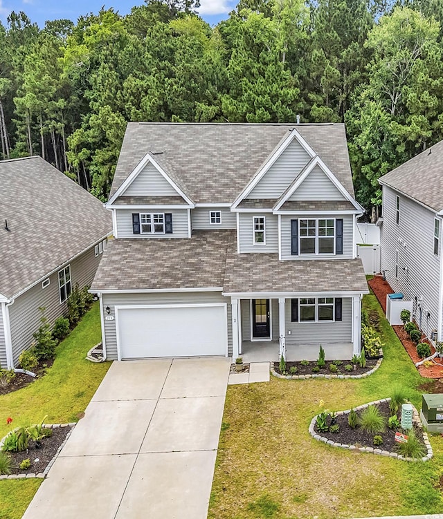 218 Calhoun Falls Dr, Myrtle Beach, SC 29579 - traditional home featuring roof with shingles, covered porch, a garage, concrete driveway, and a front lawn
