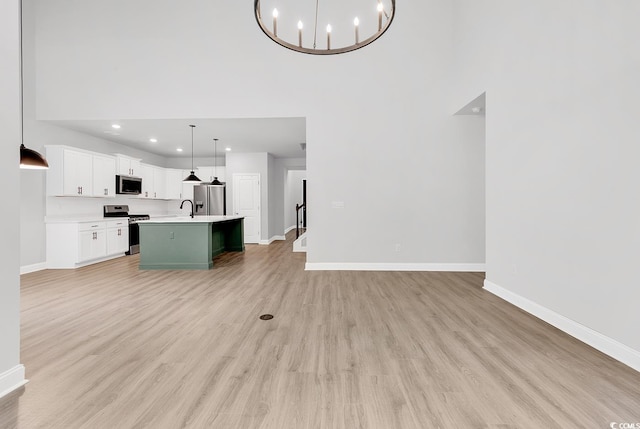 218 Calhoun Falls Dr, Myrtle Beach, SC 29579 - unfurnished living room featuring a high ceiling, baseboards, light wood-type flooring, recessed lighting, and a chandelier