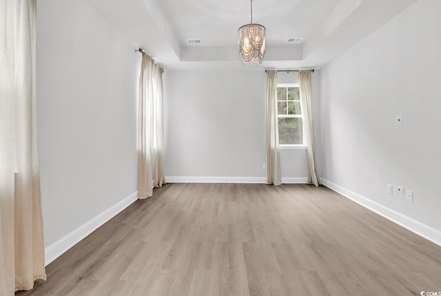 218 Calhoun Falls Dr, Myrtle Beach, SC 29579 - empty room featuring a chandelier, a raised ceiling, light wood-style floors, and baseboards