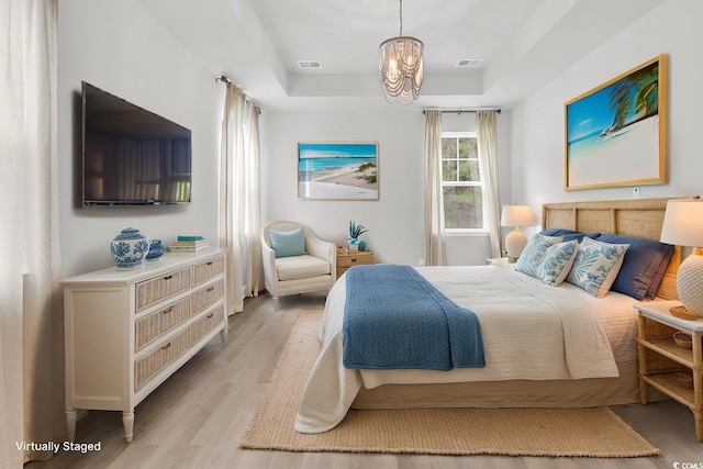 218 Calhoun Falls Dr, Myrtle Beach, SC 29579 - bedroom featuring a raised ceiling, light wood-style floors, and a chandelier