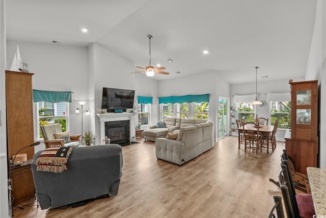 1833 Lake Egret Dr, North Myrtle Beach, SC 29582 - living room featuring a glass covered fireplace, light wood-type flooring, a ceiling fan, plenty of natural light, and high vaulted ceiling