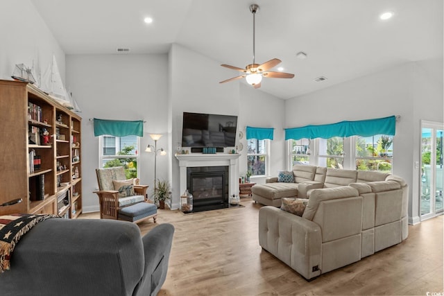 1833 Lake Egret Dr, North Myrtle Beach, SC 29582 - living room with high vaulted ceiling, wood finished floors, a ceiling fan, healthy amount of natural light, and a fireplace with flush hearth