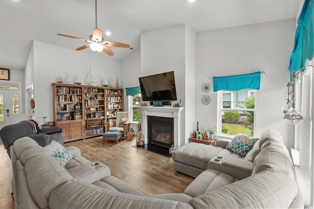 1833 Lake Egret Dr, North Myrtle Beach, SC 29582 - living room with plenty of natural light, high vaulted ceiling, a ceiling fan, a glass covered fireplace, and wood finished floors