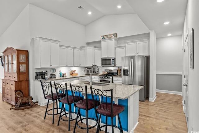 1833 Lake Egret Dr, North Myrtle Beach, SC 29582 - kitchen with appliances with stainless steel finishes, high vaulted ceiling, a breakfast bar area, a sink, and light wood-type flooring