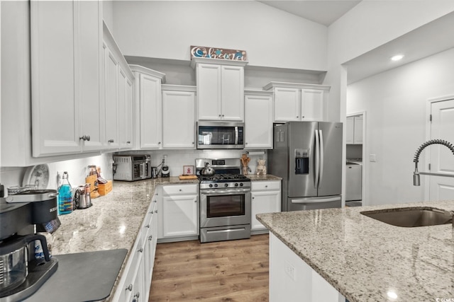 1833 Lake Egret Dr, North Myrtle Beach, SC 29582 - kitchen with stainless steel appliances, a sink, white cabinetry, and light stone counters