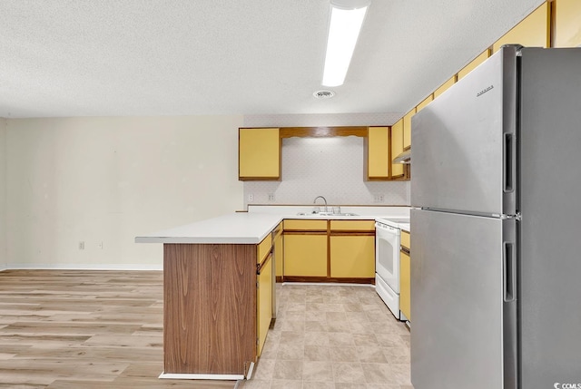 3700 Golf Colony Ln Unit 25G, Little River, SC 29566 - kitchen featuring freestanding refrigerator, white electric range, a peninsula, light countertops, and under cabinet range hood