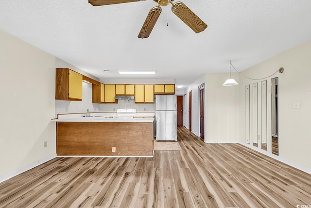 3700 Golf Colony Ln Unit 25G, Little River, SC 29566 - kitchen featuring freestanding refrigerator, under cabinet range hood, white range with electric cooktop, a peninsula, and light countertops