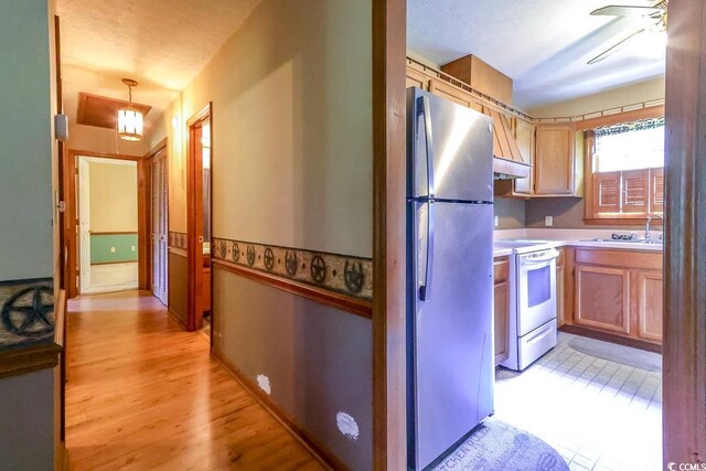 3150 Dusty Rd, Loris, SC 29569 - kitchen with white electric stove, freestanding refrigerator, under cabinet range hood, light countertops, and a ceiling fan