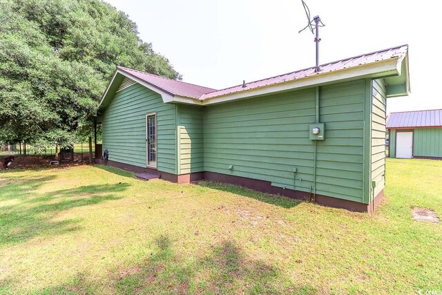 3150 Dusty Rd, Loris, SC 29569 - view of side of property with a metal roof and a yard