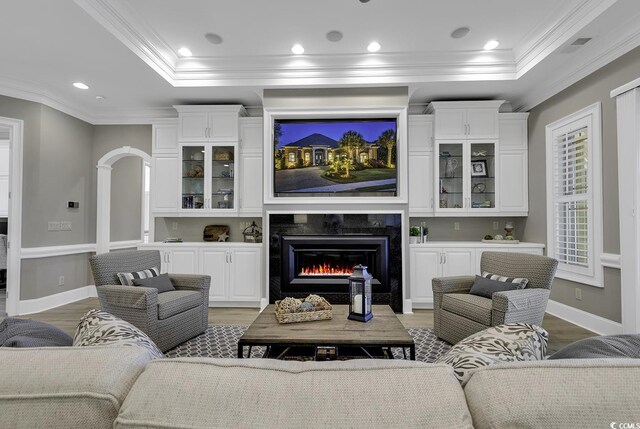 1108 Surf Pointe Dr, North Myrtle Beach, SC 29582 - living room with a raised ceiling, ornamental molding, light wood-style flooring, a premium fireplace, and arched walkways