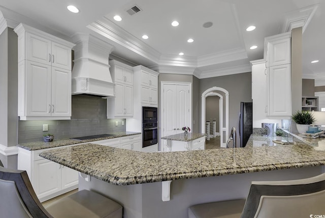1108 Surf Pointe Dr, North Myrtle Beach, SC 29582 - kitchen featuring black appliances, premium range hood, backsplash, crown molding, and a peninsula